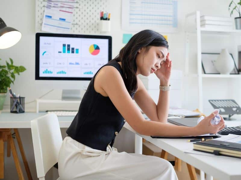 Professional reviewing job details with frustration, reflecting challenges executive search companies help overqualified candidates navigate