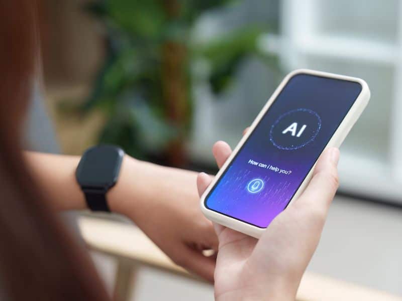A person looks at a phone screen that holds an AI sofware, considering using it in the hiring process.
